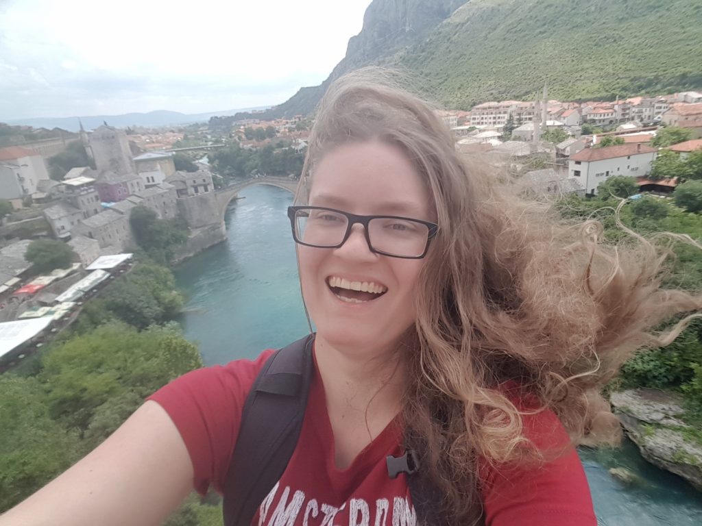 Ich, wie meine Haare im Wind wehen mit der Stari Most in Mostar im Hintergrund